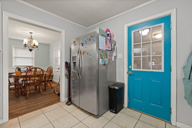 kitchen featuring a notable chandelier, light tile patterned flooring, stainless steel fridge, and crown molding