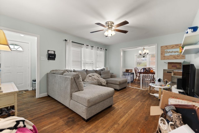 living room with ceiling fan with notable chandelier and dark wood-type flooring