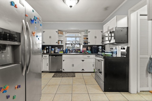 kitchen featuring ornamental molding, appliances with stainless steel finishes, light tile patterned floors, and white cabinets