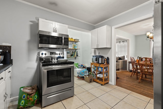 kitchen with ornamental molding, stainless steel appliances, light tile patterned floors, and white cabinets