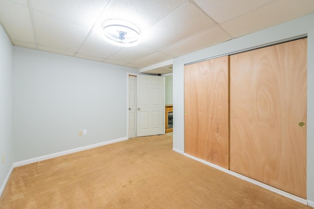 unfurnished bedroom featuring a paneled ceiling and carpet