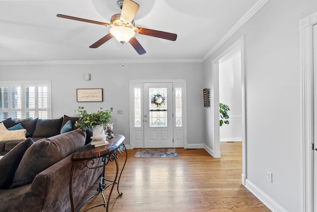 foyer entrance with ornamental molding, light wood-type flooring, baseboards, and a ceiling fan