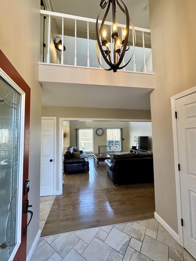 entrance foyer with light hardwood / wood-style floors, a high ceiling, and a notable chandelier