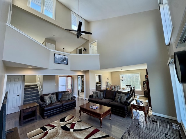 living room with hardwood / wood-style flooring, a high ceiling, and ceiling fan