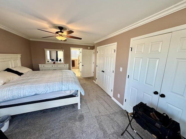 carpeted bedroom featuring connected bathroom, crown molding, ceiling fan, and two closets