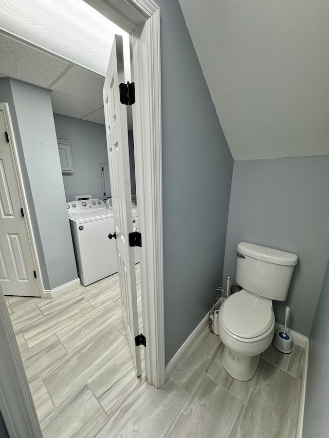 bathroom with lofted ceiling, washer / clothes dryer, a paneled ceiling, and toilet