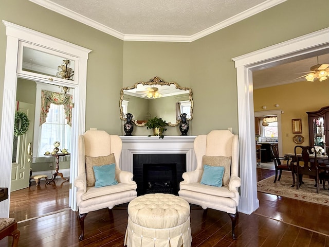 sitting room with crown molding, dark wood-type flooring, and a textured ceiling