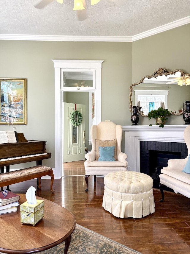 living area featuring a brick fireplace, ornamental molding, dark hardwood / wood-style floors, and a textured ceiling