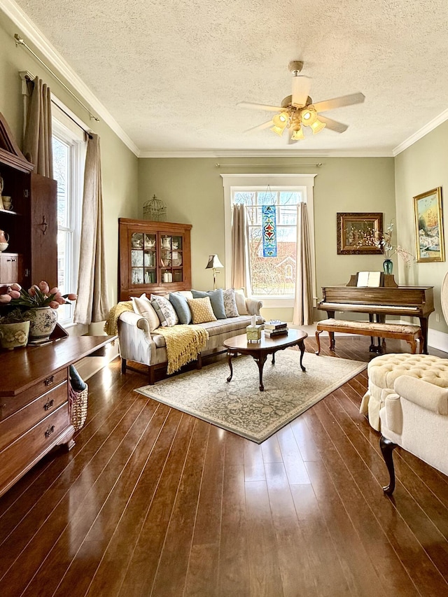 sitting room featuring ceiling fan, crown molding, dark hardwood / wood-style floors, and a healthy amount of sunlight