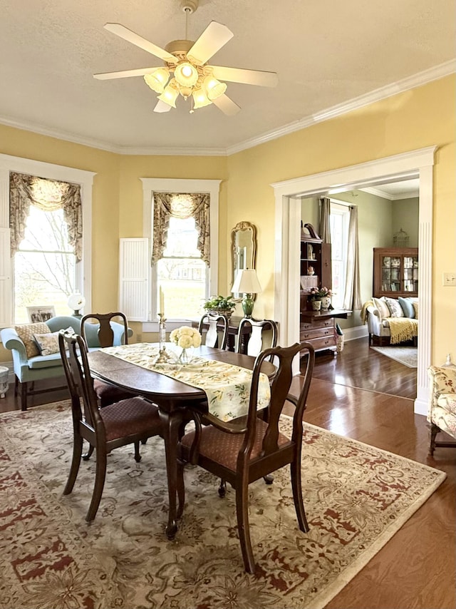 dining space featuring ornamental molding, ceiling fan, and dark hardwood / wood-style flooring