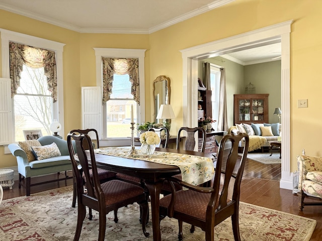 dining area featuring dark wood-type flooring and ornamental molding