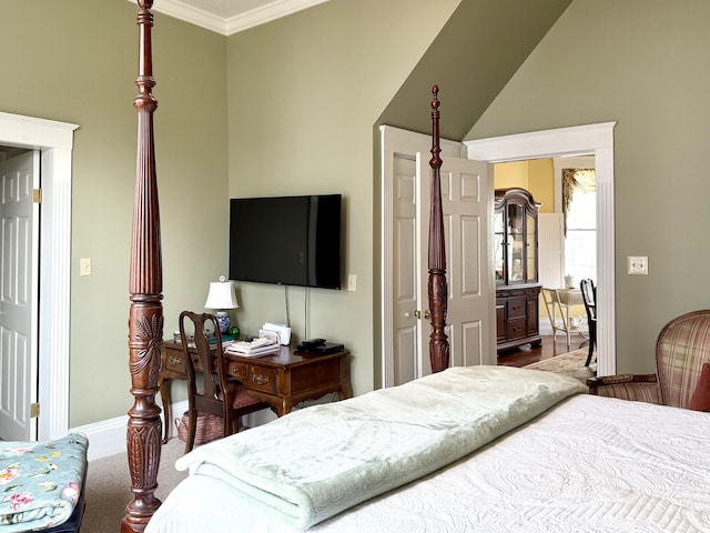 bedroom with lofted ceiling, ornamental molding, and carpet flooring