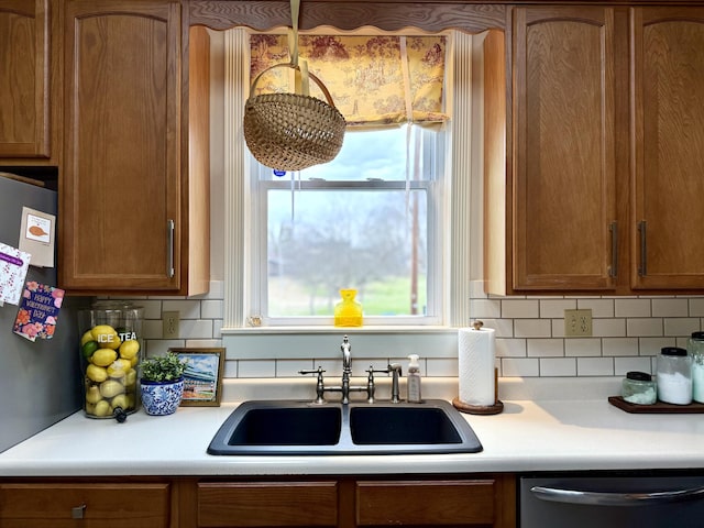 kitchen with tasteful backsplash, sink, and stainless steel dishwasher