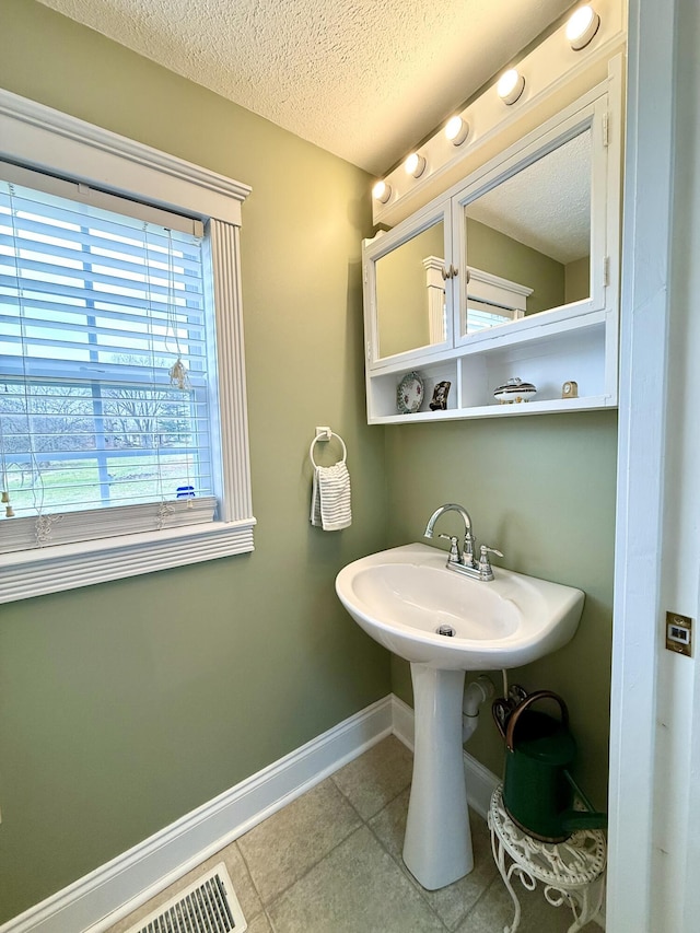 bathroom featuring tile patterned floors and a textured ceiling