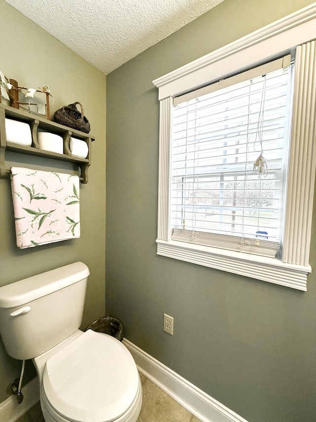 bathroom with toilet and a textured ceiling