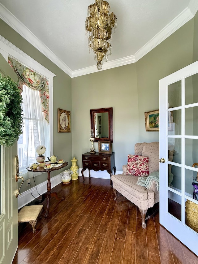 living area featuring crown molding, an inviting chandelier, and hardwood / wood-style floors