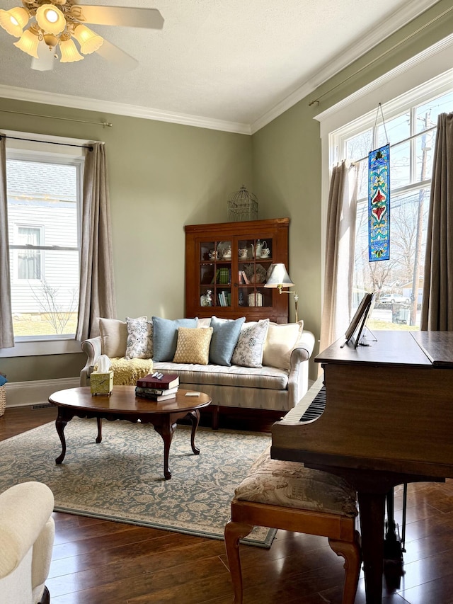 living room with crown molding, dark hardwood / wood-style floors, and ceiling fan