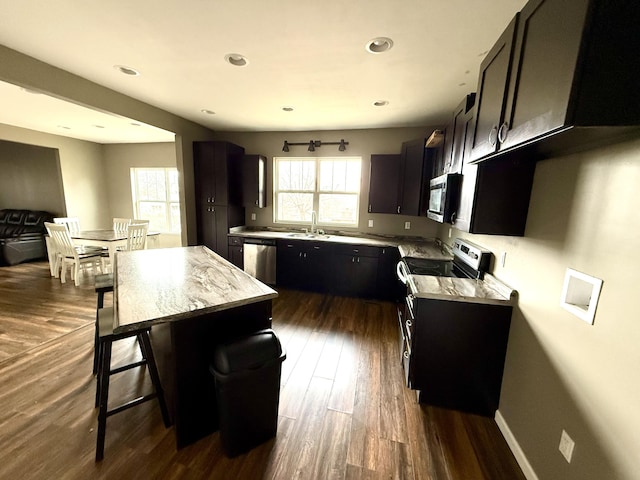 kitchen featuring stainless steel appliances, dark hardwood / wood-style floors, sink, and a kitchen island