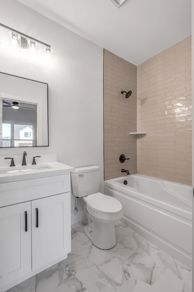 full bathroom featuring vanity, tiled shower / bath combo, and toilet