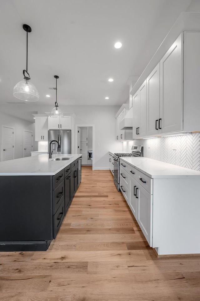 kitchen with stainless steel appliances, hanging light fixtures, sink, and white cabinets