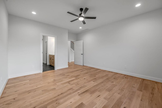 unfurnished bedroom featuring ceiling fan, ensuite bathroom, and light hardwood / wood-style flooring