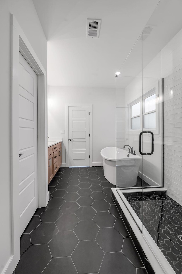 bathroom with plus walk in shower, vanity, and tile patterned floors