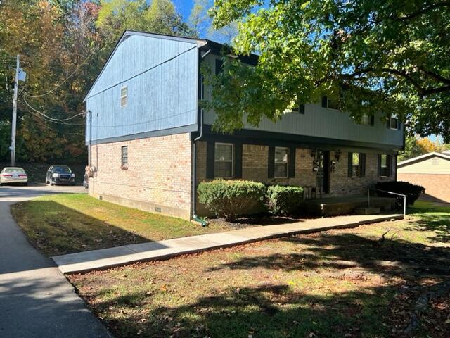 view of side of property featuring crawl space and brick siding