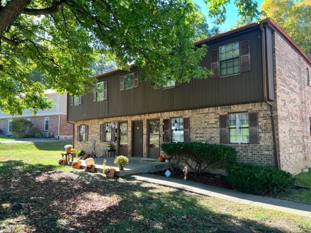 colonial house with brick siding and a front yard