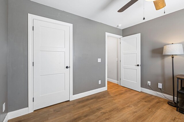 office space with light wood finished floors, baseboards, and a ceiling fan