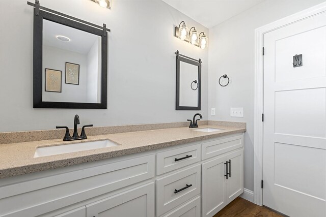 bedroom featuring a raised ceiling, baseboards, visible vents, and light wood finished floors