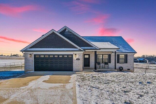 view of front of house featuring brick siding, a porch, an attached garage, crawl space, and driveway