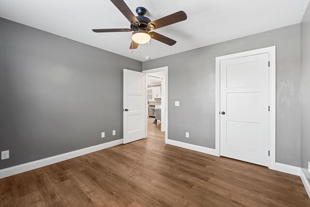 unfurnished room with a ceiling fan, visible vents, baseboards, and wood finished floors