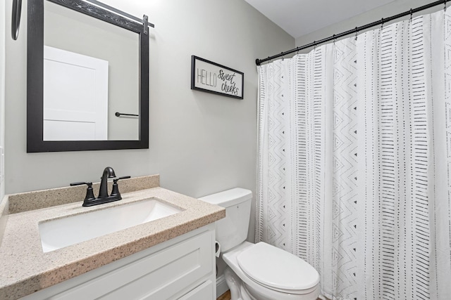 bathroom featuring curtained shower, vanity, and toilet