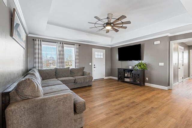 living area featuring a raised ceiling, visible vents, and light wood-style floors