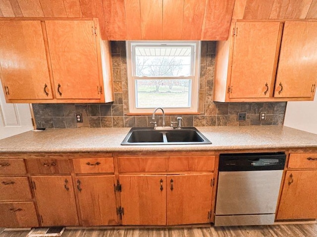 kitchen featuring tasteful backsplash, sink, light hardwood / wood-style floors, and dishwasher