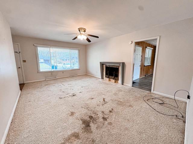 unfurnished living room featuring ceiling fan and carpet flooring