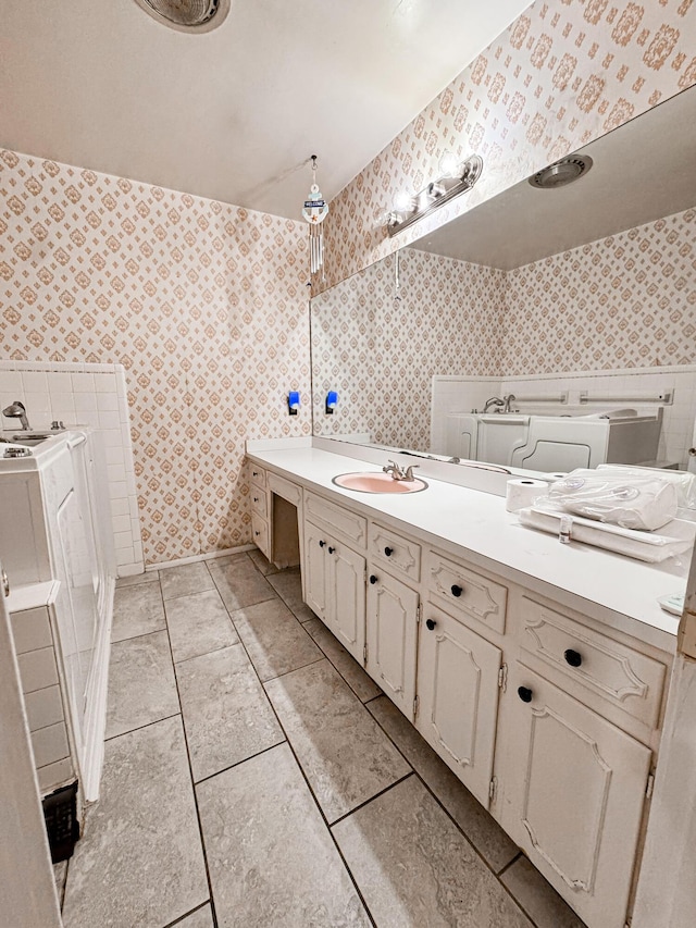 bathroom with washer / clothes dryer, vanity, and tile patterned floors