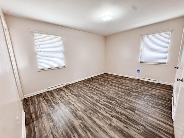 unfurnished room featuring baseboard heating and dark hardwood / wood-style flooring