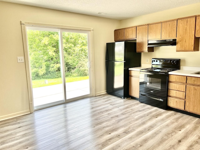 kitchen featuring light hardwood / wood-style floors, a textured ceiling, and black appliances