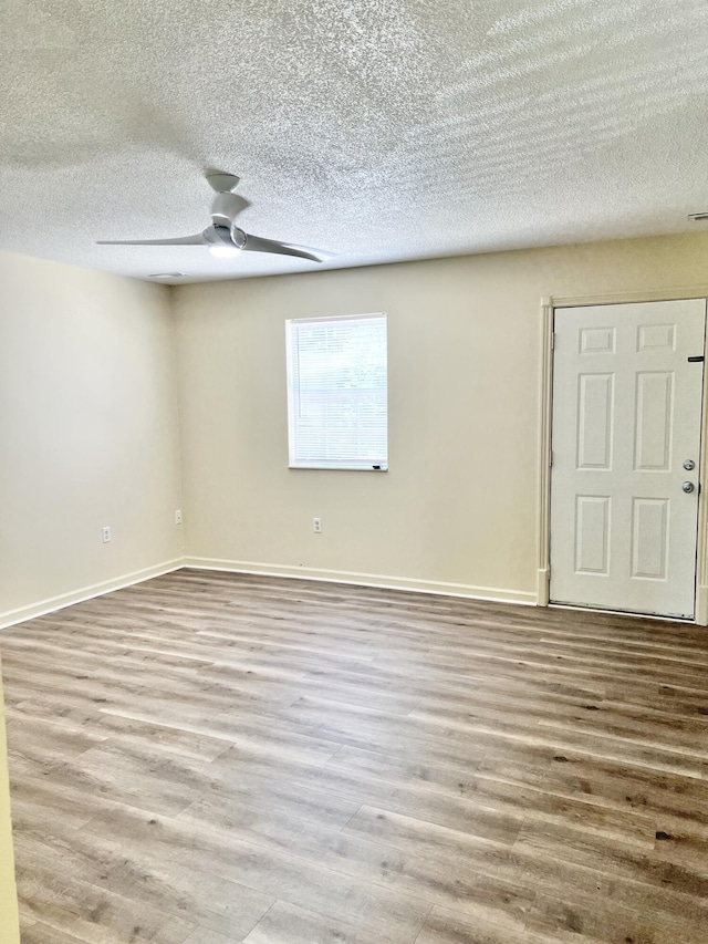 unfurnished room featuring ceiling fan, wood-type flooring, and a textured ceiling