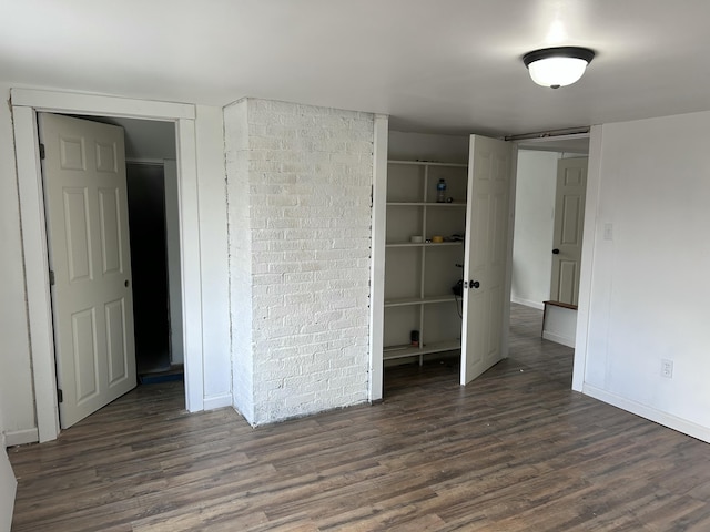 unfurnished bedroom with dark wood-type flooring and a closet