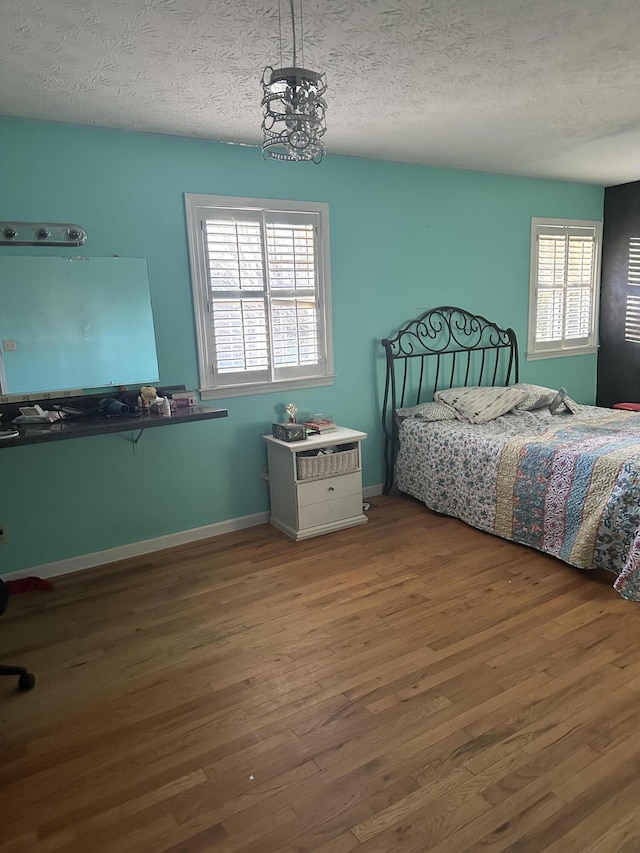 unfurnished bedroom with wood-type flooring and a textured ceiling