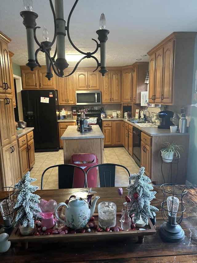 kitchen featuring sink, a kitchen island, light tile patterned floors, and black appliances