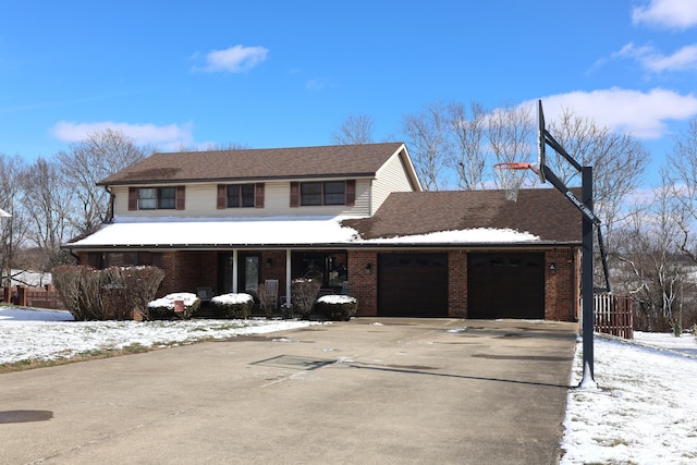 traditional home with a garage, brick siding, and driveway