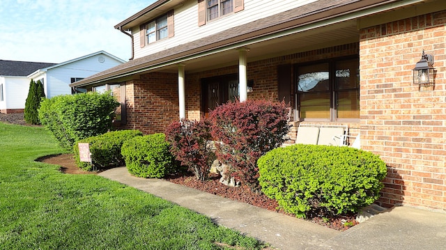 920 Meadow Ln, Harrodsburg, KY 40330 - view of exterior entry with a lawn, a shingled roof, covered porch, and brick siding