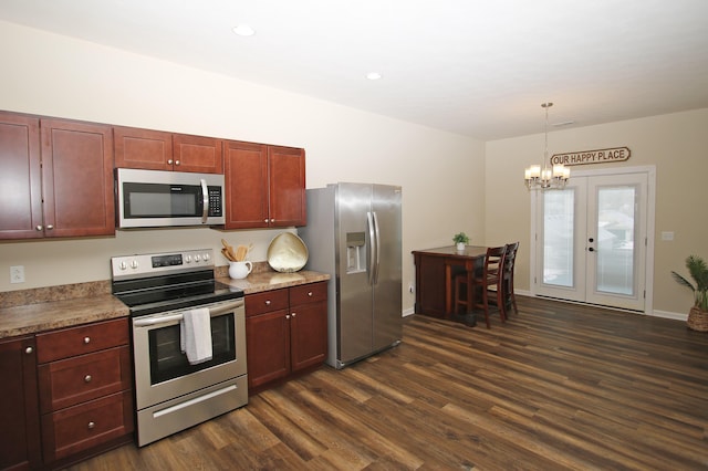 kitchen with appliances with stainless steel finishes, decorative light fixtures, dark wood-type flooring, an inviting chandelier, and french doors