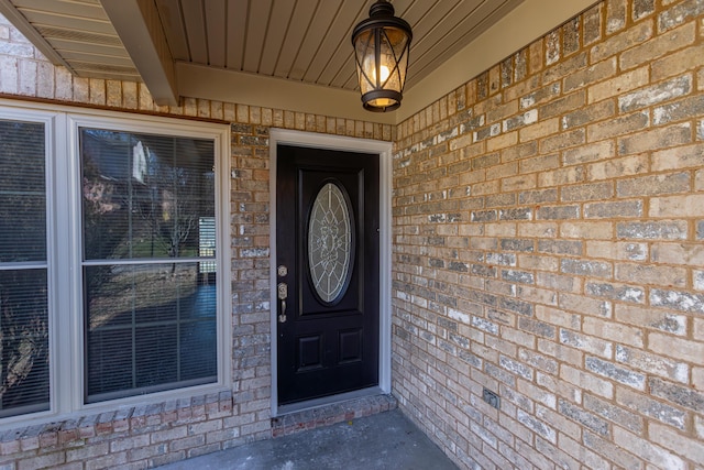 view of exterior entry with brick siding