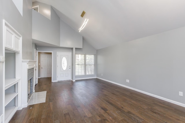 unfurnished living room featuring dark wood-style floors, a brick fireplace, high vaulted ceiling, and baseboards