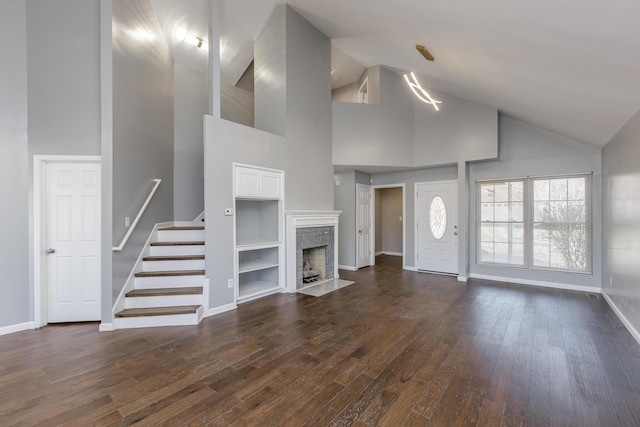 unfurnished living room with high vaulted ceiling, dark wood-type flooring, a fireplace, baseboards, and stairs