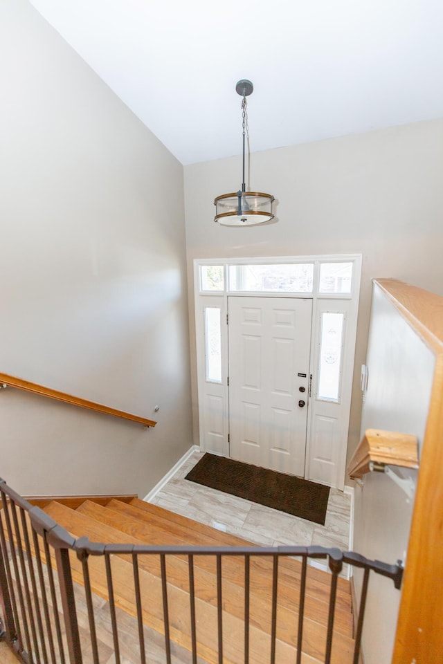 foyer entrance featuring baseboards and wood finished floors